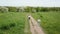 Children girls runs on a footpath in a field.