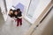 Children Greeting And Hugging Working Businesswoman Mother As She Returns Home From Work