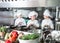 Children grind vegetables in the kitchen of a restaurant.