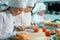 Children grind vegetables in the kitchen of a restaurant.