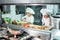 Children grind vegetables in the kitchen of a restaurant.