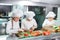 Children grind vegetables in the kitchen of a restaurant.