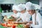 Children grind vegetables in the kitchen of a restaurant.