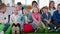 children group, happy healthy kids together with children with down syndrome applaud at camera sitting on beanbag chairs