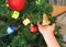 Children hand holding decorative bell on Christmas tree. Merry Christmas and Happy New Year concept.