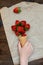 Children hand takes strawberries in ice cream cone on natural wooden background. Strawberries in wafel cone and Baby girl hand.
