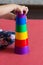 children hands make Pyramid using colorful stacking cups