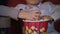 Children hands taking popcorn from paper box. Cinema food for kids