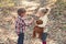 Children harvest mushrooms in autumn forest. Little boy and girl friends camping in woods. Organic and healthy food