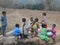 A Children have gathered in the hand pump  for water