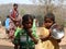 A Children have gathered in the hand pump  for water