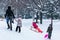 Children having fun and sledding in a hills in public park