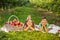 Children having a little picnic in summer garten with apples, lying on white blanket.