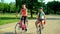 Children in helmet on bicycle by cycleway in summer park