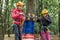 Children in helmets and with equipment climb the cable cars in the forest