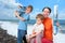 Children help mother to glue beach sea wall-papers