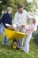 Children helping father to collect autumn leaves