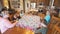 Children helping grandma tie a quilt at the dining table