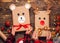 Children hold creatively wrapped Christmas gifts in the shape of a teddy bear and a deer. New Year and Christmas concept. DIY gift