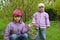 Children hold in hand a basket with daisy seedling