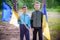 Children hold Ukrainian flags yellow and blue waving in wind . Ukraine\\\'s Independence Day.