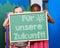 Children holding chalkboard with German slogan