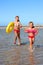 Children holding hands running on beach