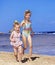 Children holding hands walking on the beach.