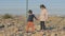 Children of immigrants wait at the border to continue their journey. high fence barbed wire on the rocky shore