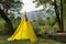 Children Indian yellow tent in the forest next to the pond with reed