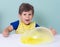 Children inflates a big bubble from a pink slime and yellow slime.