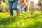 Children on a Joyful Easter Egg Hunt in Sunlit Garden. Kids legs in a park, with colorful eggs dotting the grass on a sunny day.