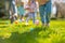 Children on a Joyful Easter Egg Hunt in Sunlit Garden. Kids legs in a park, with colorful eggs dotting the grass on a sunny day.