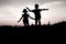 Children jumping off a hill at sunset