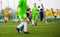 Children kicking soccer ball on sports field