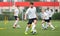 Children kicking soccer balls on artificial grass training field. Young boy leading ball and improving dribbling skills. Physical