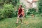 Children kids splashing with gardening hose sprinkler on backyard on summer day