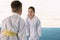 Children in kimono performing ritual bow before karate practice on tatami outdoors