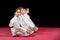 Children in kimono sitting on tatami on martial arts seminar. Selective focus