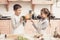 Children in kitchen. Brother is holding peppers and sister is choosing.