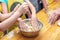 Children knead the dough in a bowl