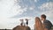 Children launch airplanes while standing on a stack of straw in front of their parents.