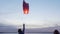 Children launch sky lantern by sea at sunset