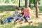 Children learn in nature, four children read a book in the park in the open air. Pupils are preparing for school