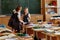 The children left their satchels and notebooks on the tables and went to recess. Three small students stayed in class to discuss