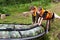 Children in life jackets push boat into water