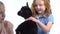Children with little black goatling at white background. Happy childhood concept. Studio video of kids emotion. Close up