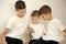 children look at phone with interest social networks look Three brothers t-shirts white background children's