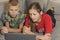 Children looking at a laptop while lying on the couch at home. brother and sister on remote online training