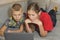 Children looking at a laptop while lying on the couch at home. brother and sister on remote online training